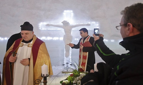 Một người đàn ông đang quay phim các vị linh mục bên trong nhà thờ được xây từ băng trước nghi lễ ban phước ngày 29/1.