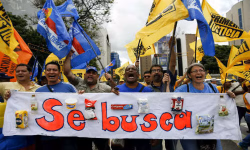 Người dân biểu tình phản đối chính phủ của Tổng thống Venezuela Nicolas Maduro và mang theo băng rôn với nội dung: “Chúng tôi cần các nhu yếu phẩm cơ bản” ở Caracas ngày 8/8/2015.