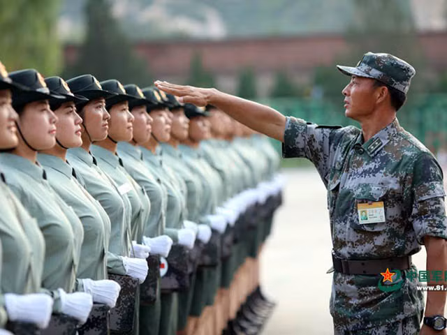 Một sĩ quan đang hướng dẫn các "bóng hồng" dóng thẳng hàng.
