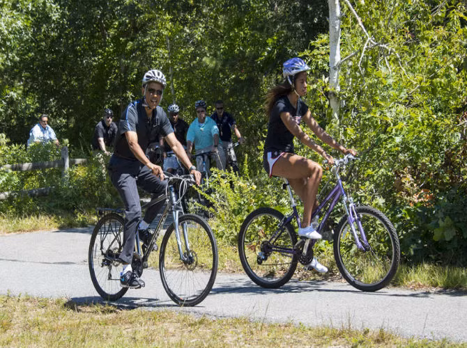 Tổng thống Mỹ Barack Obama được cho là sẽ đi nghỉ tại Martha’s Vineyard, bang Massachusett vào tháng này. Bức ảnh chụp ông chủ Nhà Trắng đạp xe cùng con gái, Malia, vào mùa hè năm 2014.