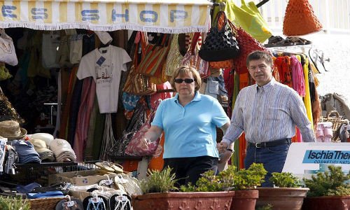 Thủ tướng Đức Angela Merkel đứng bên ngoài một cửa hàng bán đồ lưu niệm trên đảo Ischia, Italy.
