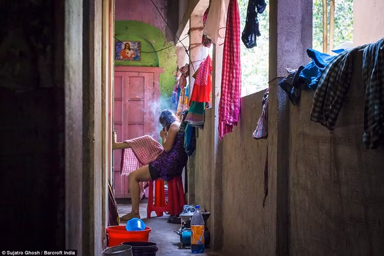 Một gái bán dâm đang hút thuốc bên ngoài hành lang khu nhà thổ. (ảnh: Barcroft India/DM).
