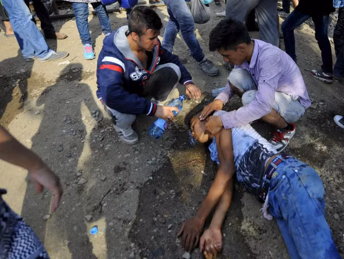 Người dân giúp đỡ một thanh niên bị ngất ở vùng giới tuyến ngày 21/8.