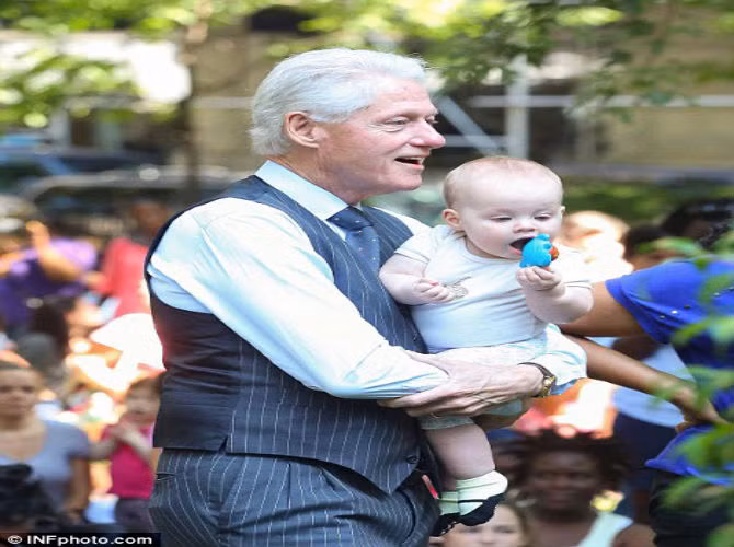 Clinton rất vui khi bế cháu ra ngoài chơi. Vợ ông, cựu Ngoại trưởng Mỹ Hillary Clinton không thể đi cùng vì đang bận rộn với chiến dịch tranh cử tổng thống.