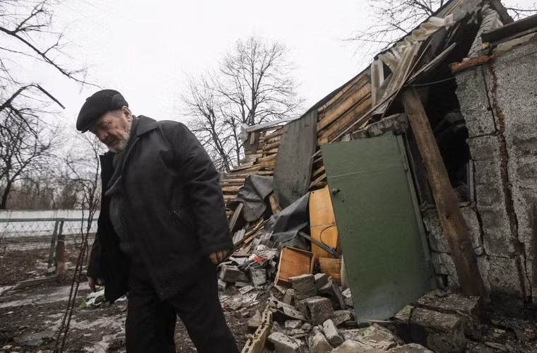 Người đàn ông đi qua 1 ngôi nhà bị phá hủy ở thành phố Yenakieve, phía đông bắc Donetsk ngày 2/2/2015.