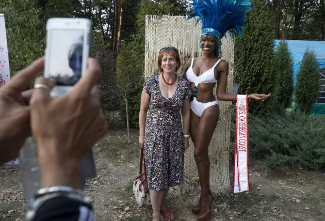 Một người đẹp Mrs. Universe 2015 đến từ Caribe chụp ảnh kỷ niệm cùng một phụ nữ khi đến thăm Thảo Cầm Viên ở Minsk, Belarus.