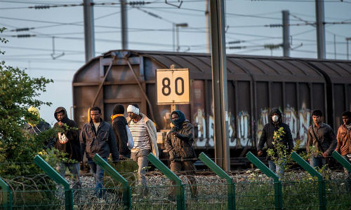 Những di dân đã vượt qua hàng rào an ninh tại Calais, Pháp ngày 29/7 và hướng về phía đường hầm để bắt chuyến tàu đến Anh.