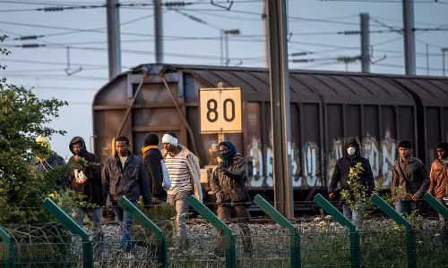 Những di dân đã vượt qua hàng rào an ninh tại Calais, Pháp ngày 29/7 và hướng về phía đường hầm để bắt chuyến tàu đến Anh.