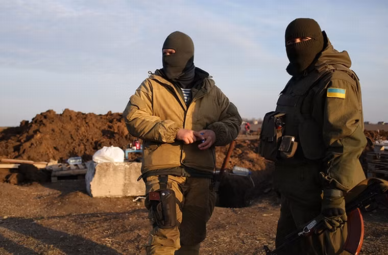 Hai lính Ukraine đang quan sát xung quanh trong khi đang canh gác ở làng Shirokino ngày 25/2.