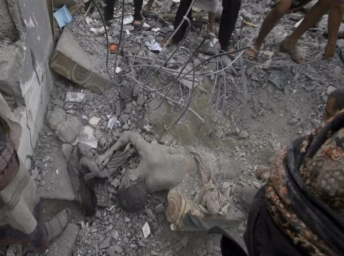 Các cuộc không kích đã khiến hơn 3.000 người thiệt mạng. Ảnh: Thi thể một người đàn ông chôn vùi dưới đống đổ nát của tòa nhà bị phá hủy sau đợt không kích của liên minh Ả-rập nhằm vào lực lượng Houthi.