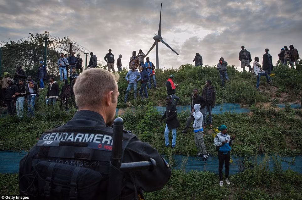 Hàng chục di dân cố tìm cách vượt qua hàng rào cảnh sát.