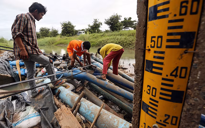 Người dân đang sửa chữa các máy bơm nước ở đầu kênh tưới tiêu Makhamtao Uthong ở Praek Sriracha, tỉnh Chainat. Mực nước tại các hồ chứa nước chủ chốt của Thái Lan đã xuống mức thấp nhất kể từ năm 1987.