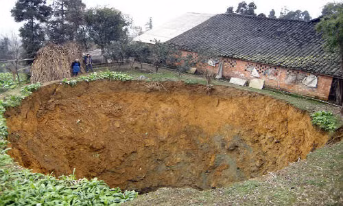 Miệng hố rộng 20 mét này được hình thành ngay sân của một gia đình ở Leshan, tỉnh Tứ Xuyên, Trung Quốc, hồi tháng 1/2011. Độ sâu của hố khổng lồ này là hơn 40 mét.