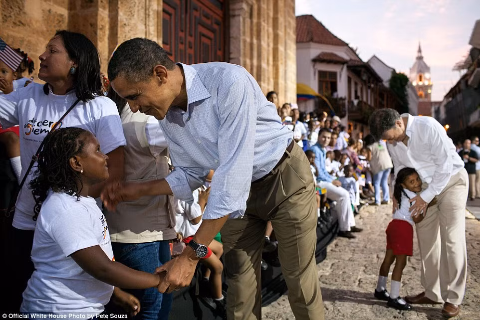 Obama mỉm cười bắt tay một bé gái ở quảng trường San Pedro, Colombia ngày 15/4/2012.