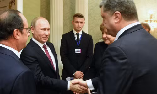 Tổng thống Poroshenko (bên phải) "miễn cưỡng" bắt tay người đồng cấp Putin tại buổi đàm phán hòa bình ngày 11/2.