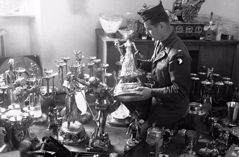 Binh sĩ Mỹ kiểm tra một tượng vàng nằm trong số kho báu của trùm phát xít Hermann Goering được quân đồng minh tìm thấy trong một hang động ở khu vực gần Schonau am Konigssee, Đức ngày 25/5/1945. Trong hang động này, người ta cũng phát hiện nhiều bức tranh quý bị phát xít Đức đánh cắp ở châu Âu.