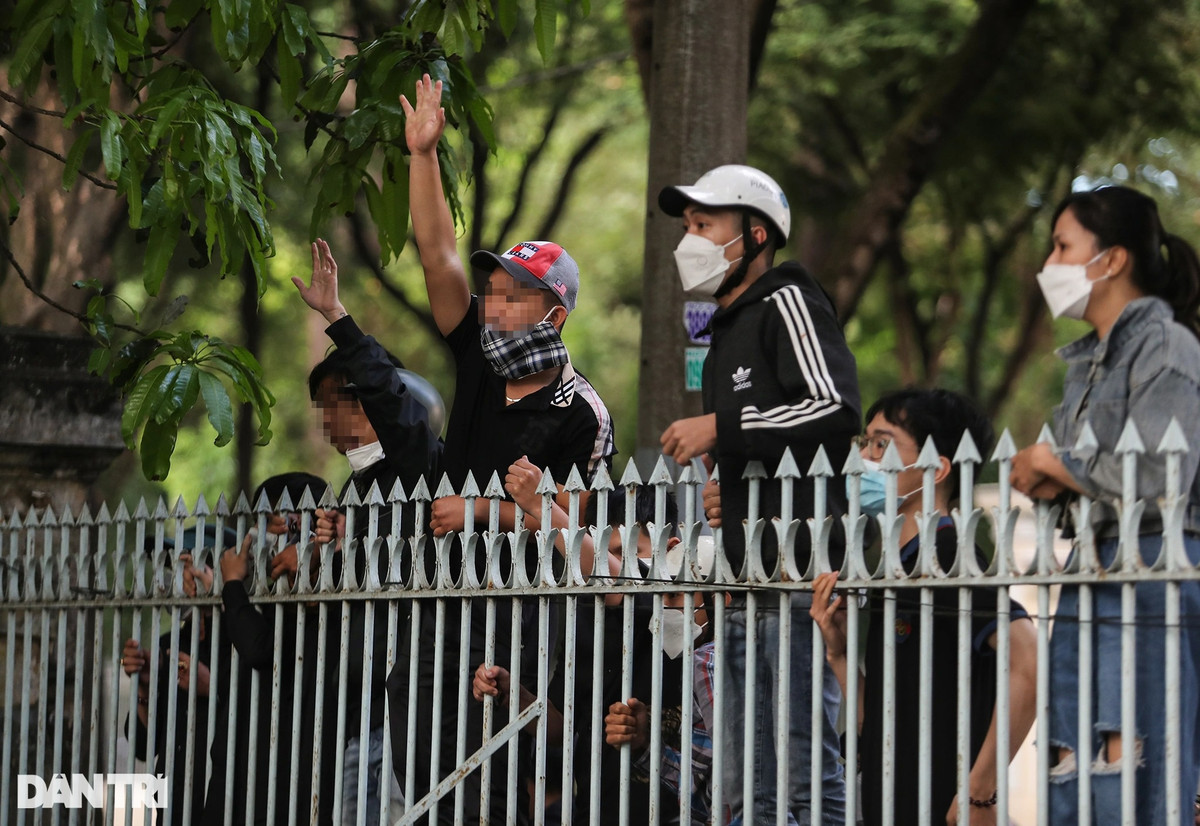 Người thân của 12 bị cáo đứng vẫy tay, gọi tên các bị cáo từ bên ngoài hàng rào sau nhiều tháng chưa thể gặp mặt vì bị tạm giam.