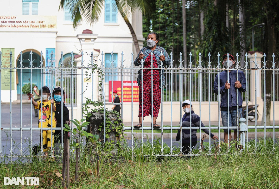 Rất đông người lớn, trẻ nhỏ đứng bám ở hàng rào tòa án để chờ đợi các bị cáo được chở tới tòa bằng 3 xe bít bùng.