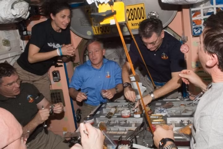 Phi hành đoàn của STS-133 và của ISS ăn chung một bữa tại nút Unity.