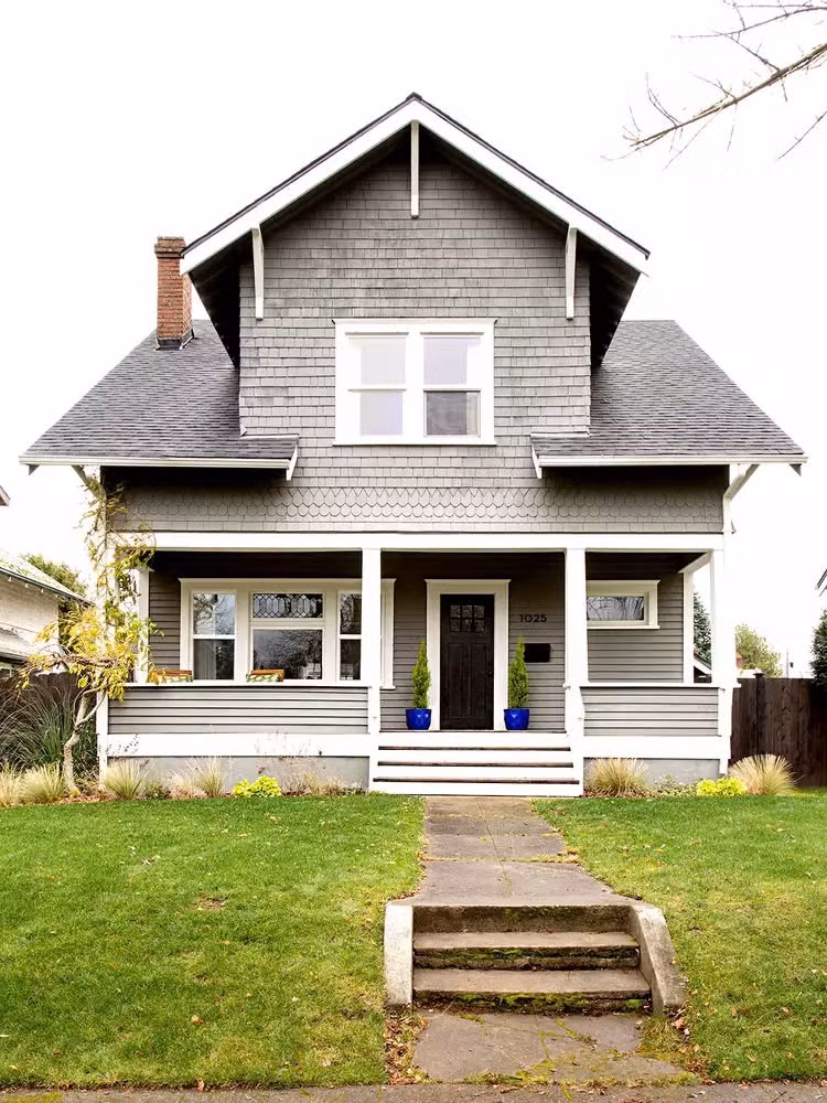 Trong phiên bản cải tạo ngoại thất, sơn màu xám nhạt kết hợp lớp ván lợp cùng viền trắng cho cửa sổ, cửa trước, hiên nhà mang đến vẻ ngoài sạch sẽ. Cầu thang lên cửa, lan can hiên nhà cũng được gia cố để chắc chắn hơn.