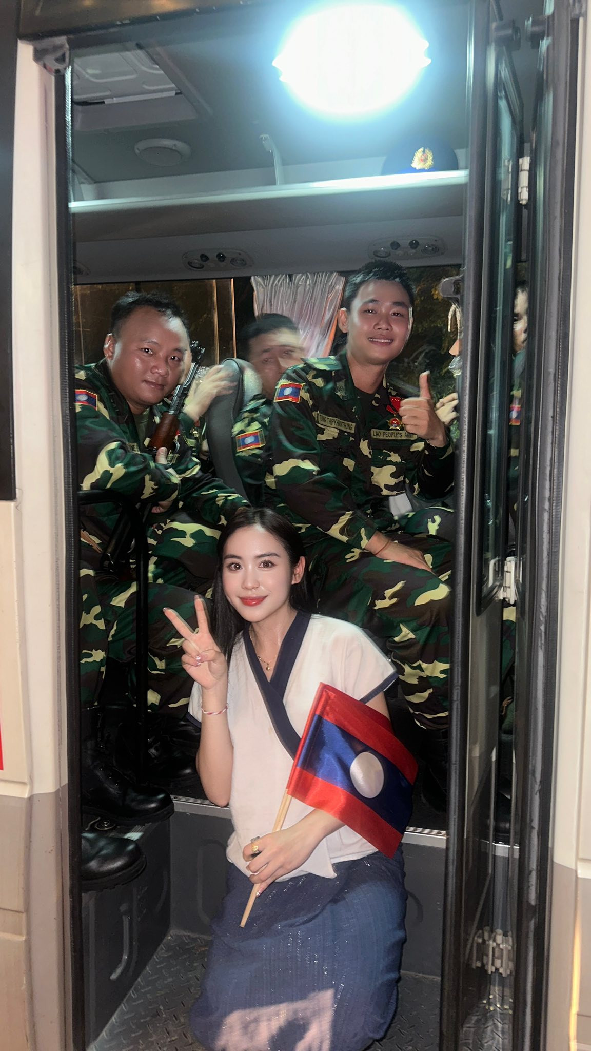 Mặc bộ váy truyền thống, Maysaa cầm trên tay lá cờ Việt Nam và Lào chen chân giữa biển người theo dõi từng bước đi của các khối diễu binh.