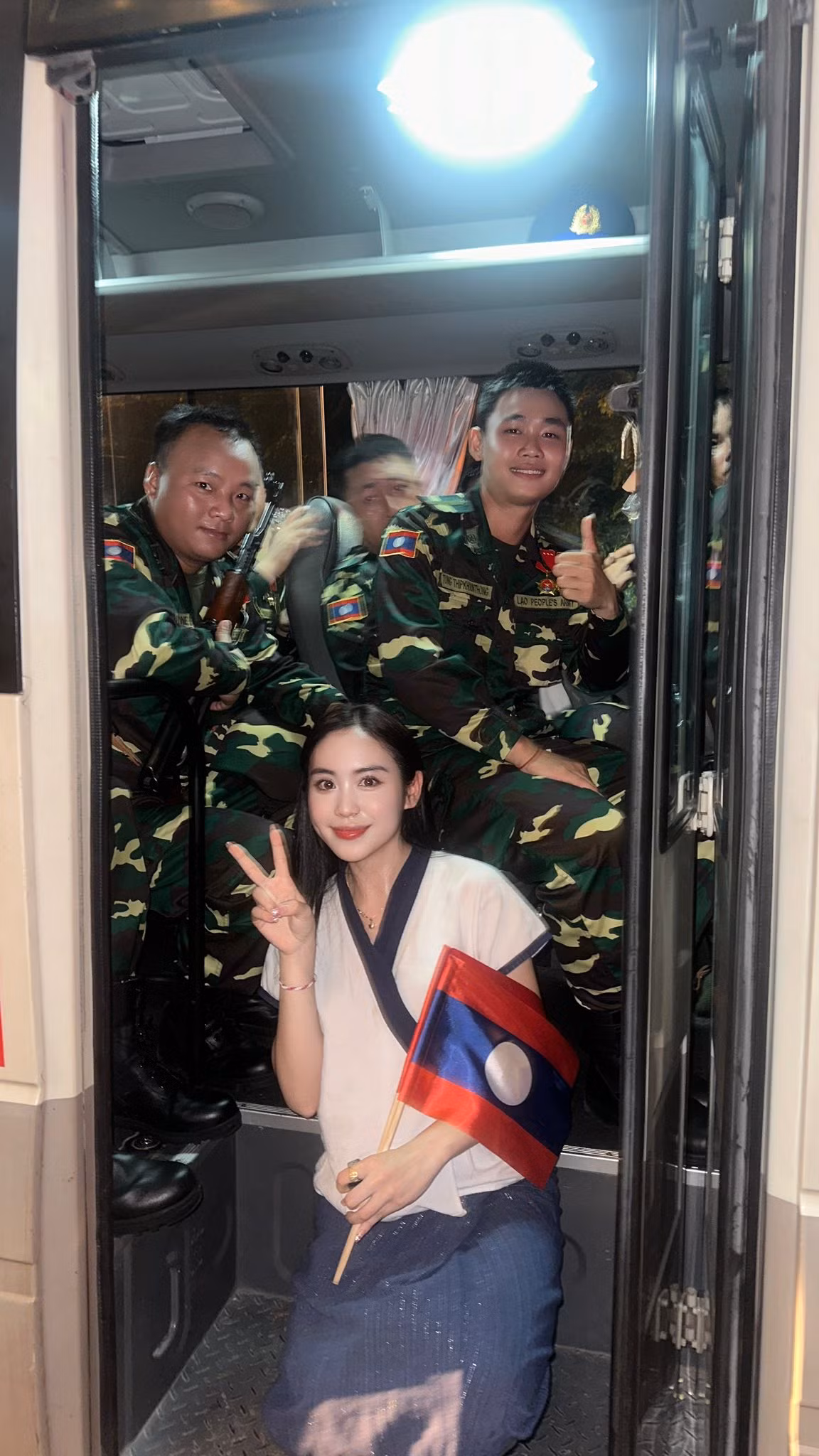 Mặc bộ váy truyền thống, Maysaa cầm trên tay lá cờ Việt Nam và Lào chen chân giữa biển người theo dõi từng bước đi của các khối diễu binh.