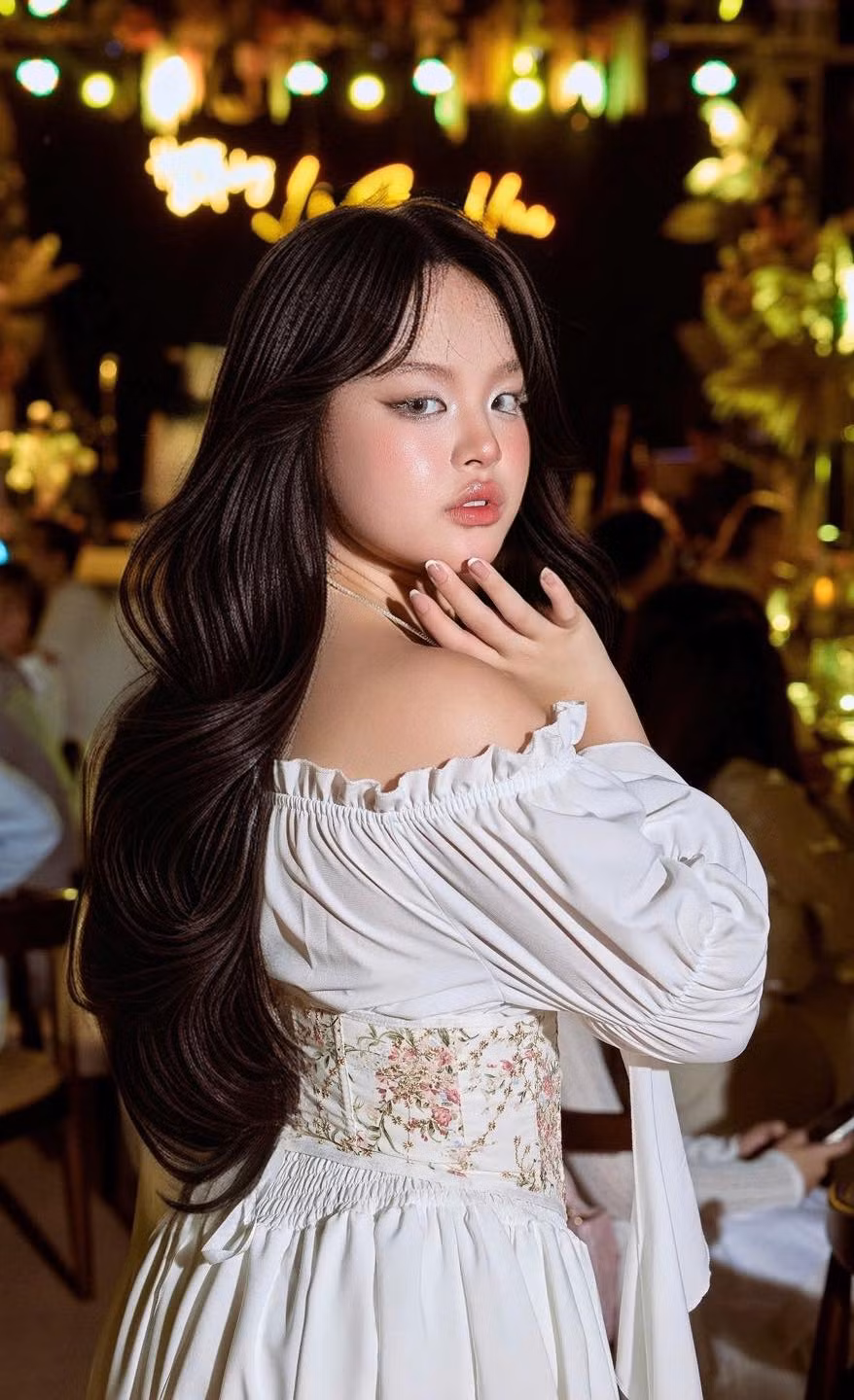 Trong những bức ảnh đó, Suli xuất hiện với phong cách thời trang đậm chất tiểu thư. Chiếc đầm trắng trễ vai bằng chất liệu mềm mại với điểm nhấn là phần tay áo bồng và thân váy xếp ly nhẹ nhàng giúp cô toát lên vẻ nữ tính, thanh thoát. Thiết kế cổ điển không chỉ tôn lên làn da trắng sáng mà còn làm nổi bật vóc dáng thanh mảnh của cô nàng.