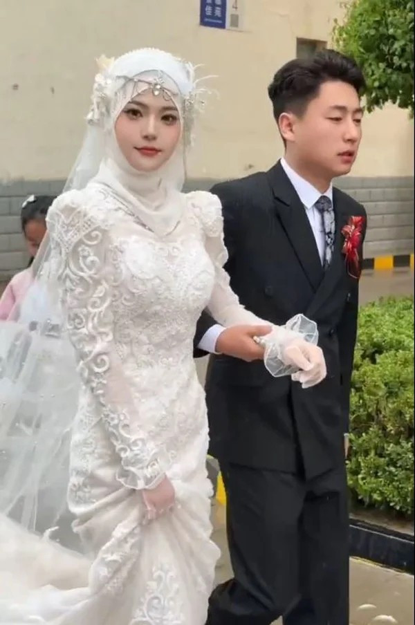 Diện trên mình chiếc váy cưới trắng muốt, cô dâu không chỉ xinh đẹp đơn thuần mà được nhiều người nhận xét sở hữu một vẻ đẹp gần như hoàn hảo: làn da mịn màng không tì vết, sống mũi cao thon, đôi mắt to tròn, đầy cuốn hút.