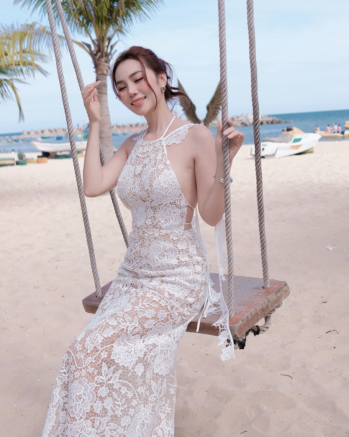 Phần cổ yếm giúp khoe khéo bờ vai trần nuột nà, trong khi phần thân váy ôm sát tôn trọn vóc dáng chuẩn chữ S. Chất liệu ren xuyên thấu được xử lý tinh tế, để lộ lớp lót màu nude bên trong, tạo hiệu ứng "mặc như không mặc" đầy cuốn hút nhưng không phô phang.