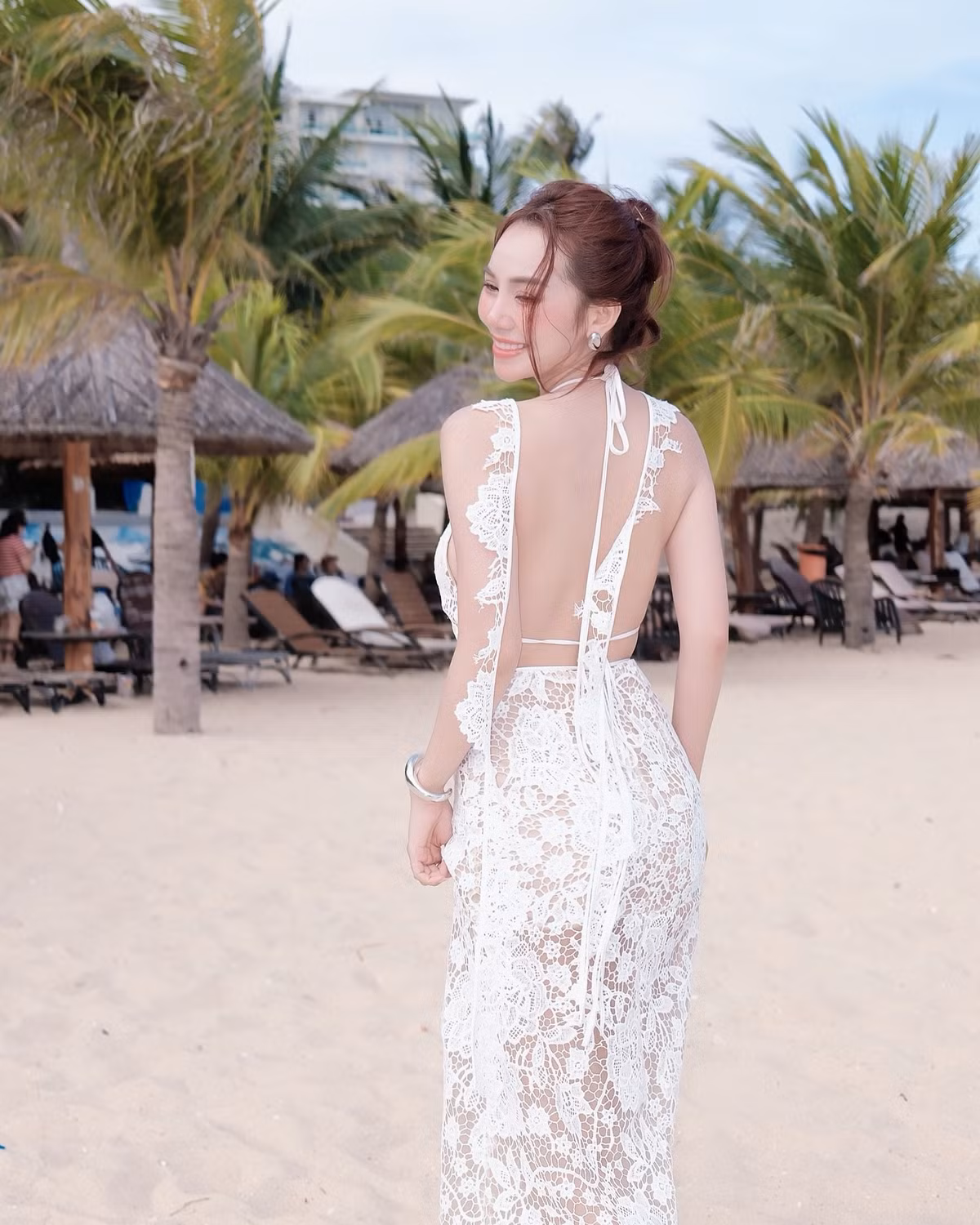 Trang phục được phối cùng trang sức tối giản – chỉ một chiếc vòng tay kim loại bản to – vừa đủ để tạo điểm nhấn, nhưng không lấn át tinh thần tổng thể. Mái tóc búi nhẹ cùng lớp trang điểm trong suốt cũng giúp Hoàng Kim Chi giữ được vẻ đẹp thanh thoát, tự nhiên đúng chất “nàng thơ biển cả”.