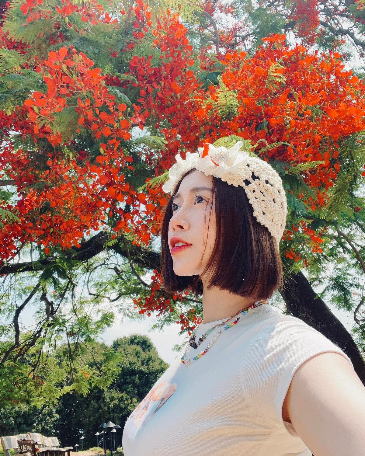 Điểm nhấn nằm ở phụ kiện băng đô ren đội đầu và chuỗi vòng cổ sắc màu mang đậm tinh thần mùa hè, khiến tổng thể trang phục thêm phần nổi bật.