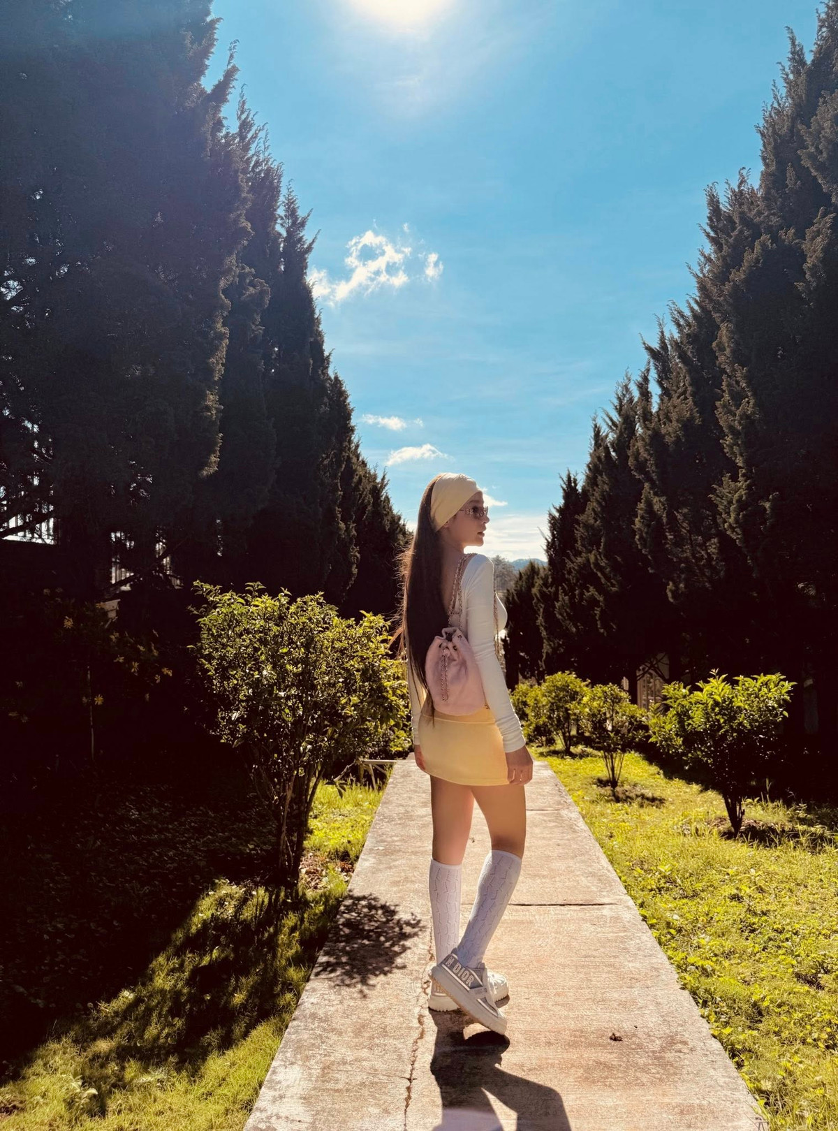 Diện set đồ tông vàng kem, gồm crop top ôm sát, chân váy ngắn cùng tất cao đến gối, Huyền Baby toát lên vẻ đẹp pha trộn giữa nét ngọt ngào và quyến rũ.
