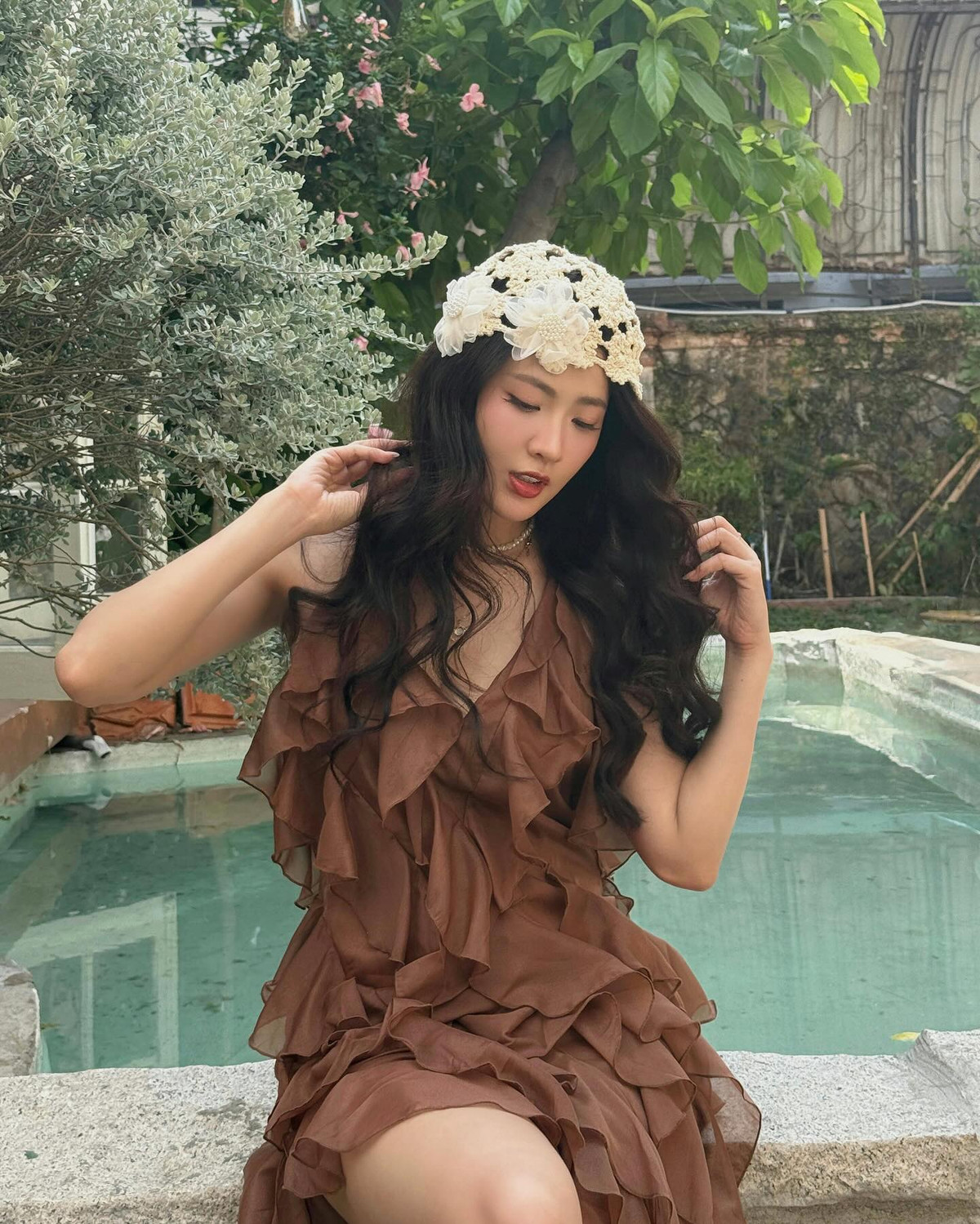 Cách phối trang sức của cô cũng tối giản nhưng đầy tinh tế: chuỗi ngọc trai cổ điển kết hợp với vòng cổ vàng mảnh, tạo điểm nhấn nhẹ nhàng mà sang trọng, hài hòa hoàn hảo với tổng thể.