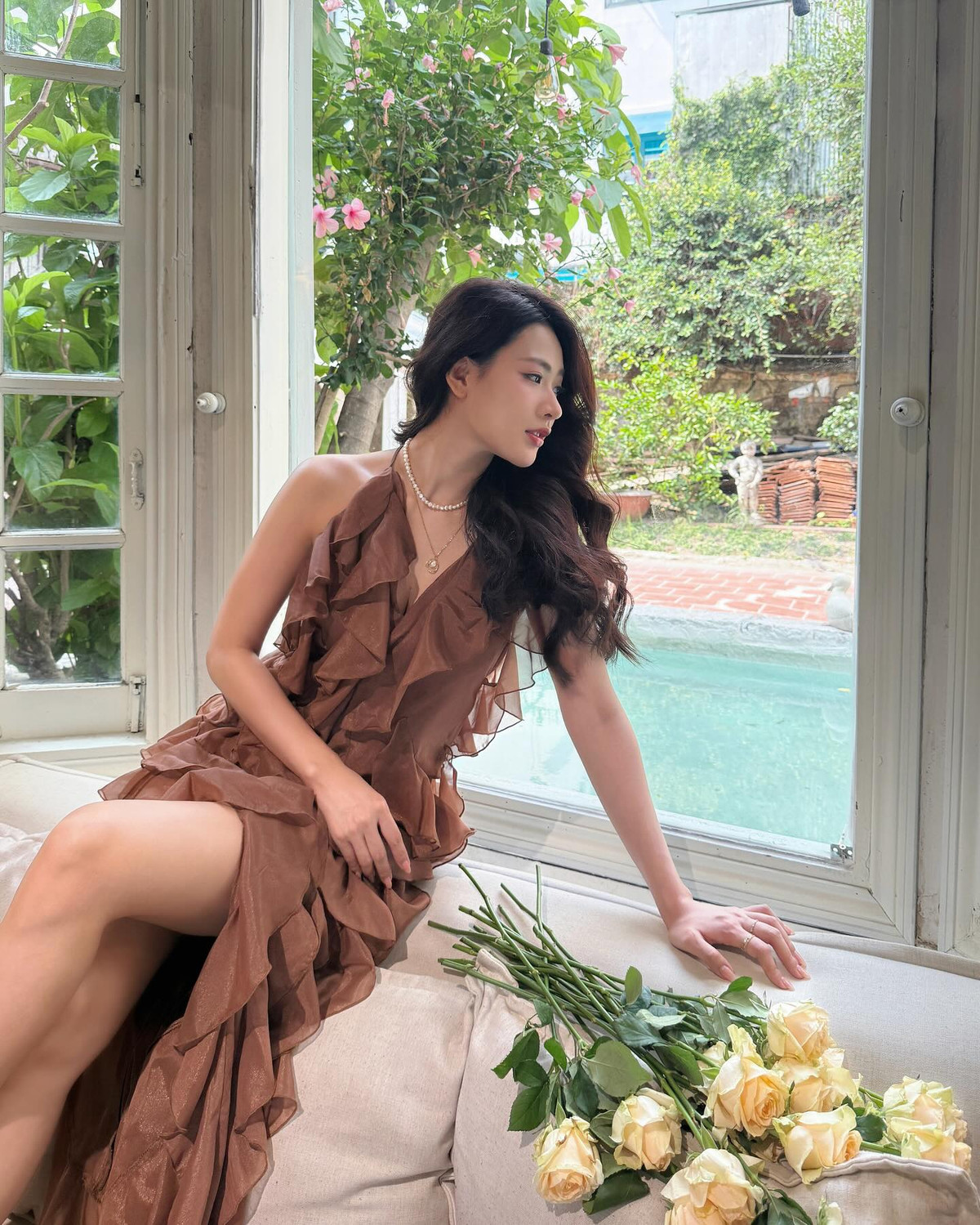 Khi dịu dàng nghiêng đầu bên khung cửa sổ, khi lại thảnh thơi ngả lưng trên ghế sofa với đóa hồng bên cạnh, Minh Trang khiến người xem như lạc vào một thước phim lãng mạn Pháp.