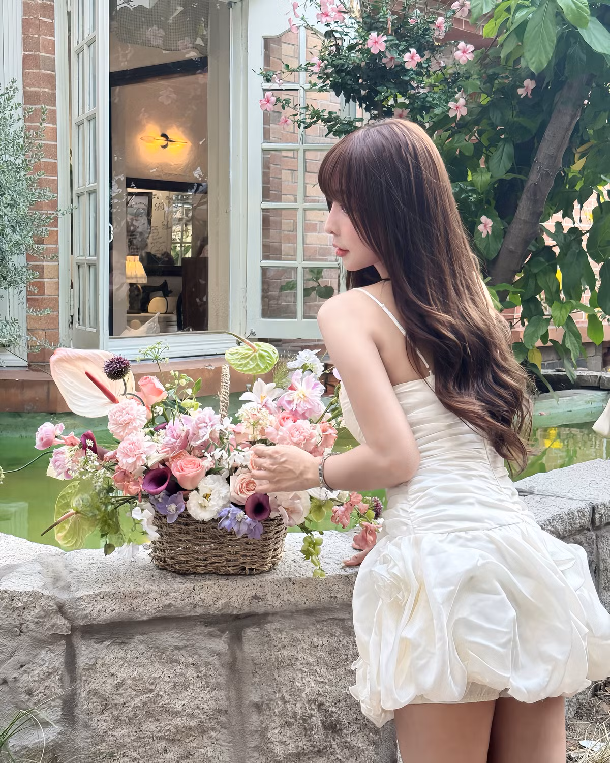 Phần thân váy được nhấn nhá bằng các nếp gấp dọc, vừa tạo hiệu ứng thị giác thon gọn vừa mang nét cổ điển nữ tính.