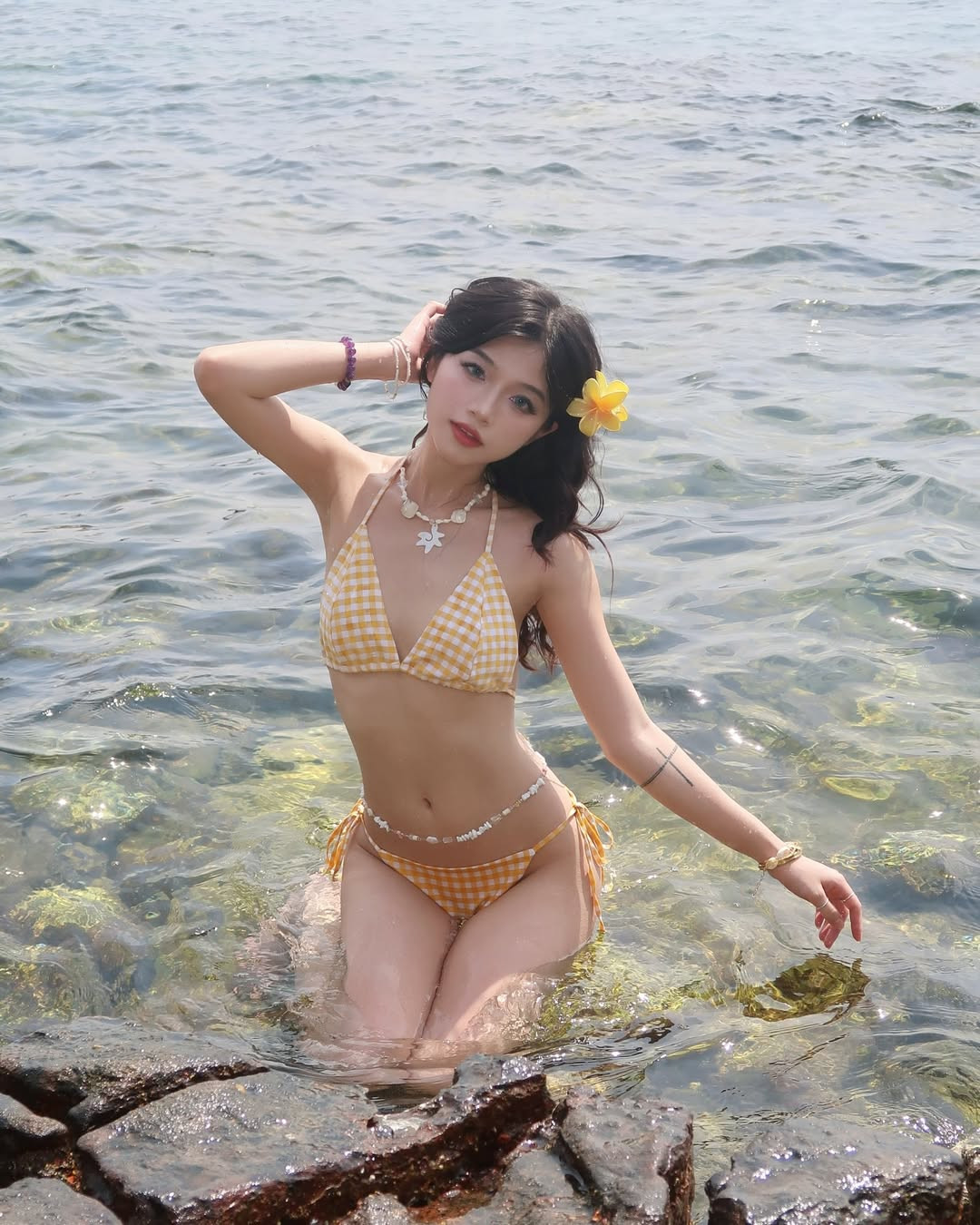 Chiếc bikini mang phong cách vintage nhẹ nhàng kết hợp với điểm nhấn là chiếc nơ buộc hai bên hông giúp tôn lên vòng eo thon gọn và đôi chân dài nuột nà.