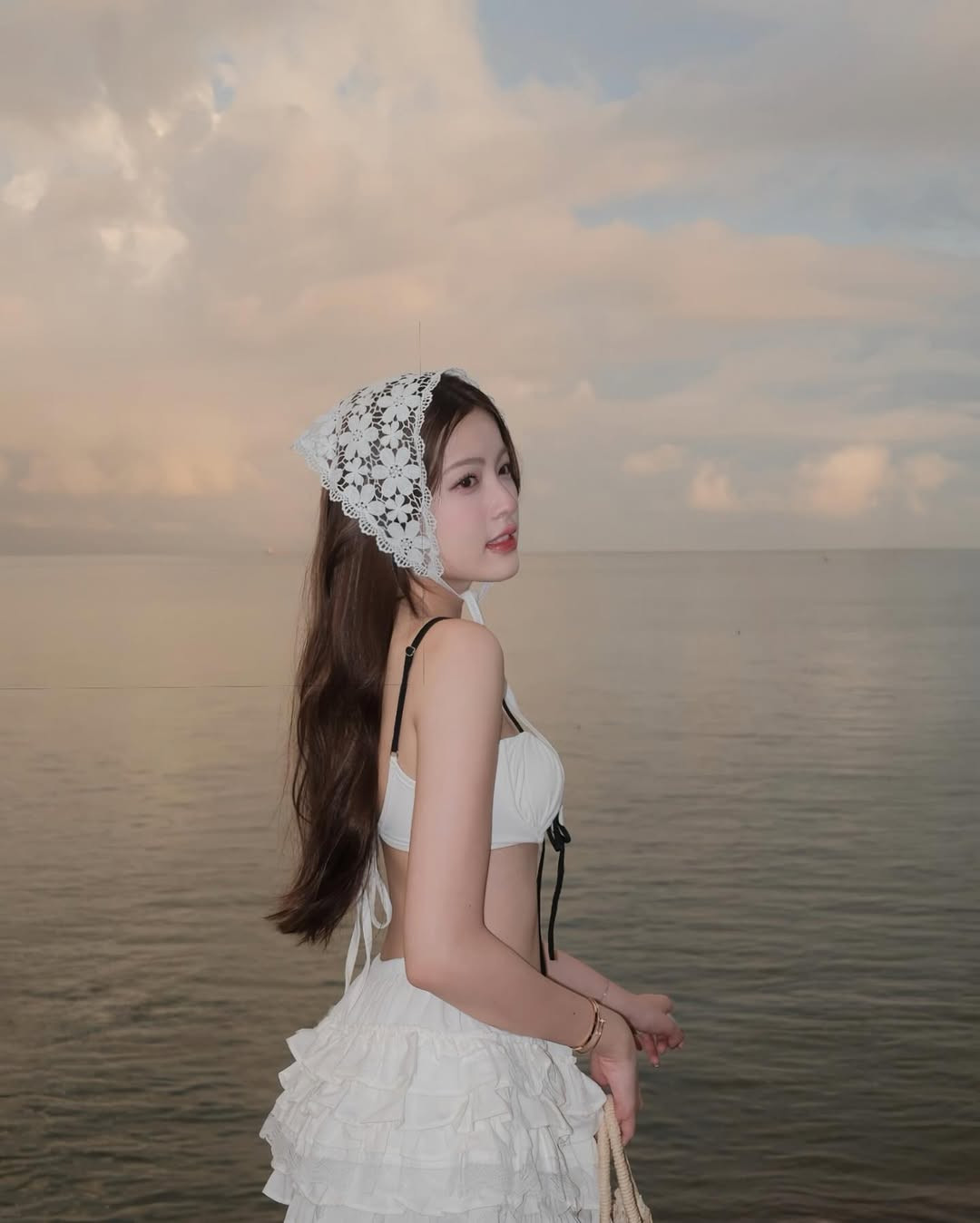 Trong bộ ảnh mới, giữa khung cảnh bình minh lãng mạn bên bờ biển, Tăng Mỹ Hàn xuất hiện đầy cuốn hút trong bộ bikini trắng tinh khôi kết hợp cùng chân váy bèo nhún nữ tính và chiếc mũ ren cột nơ nhẹ nhàng.