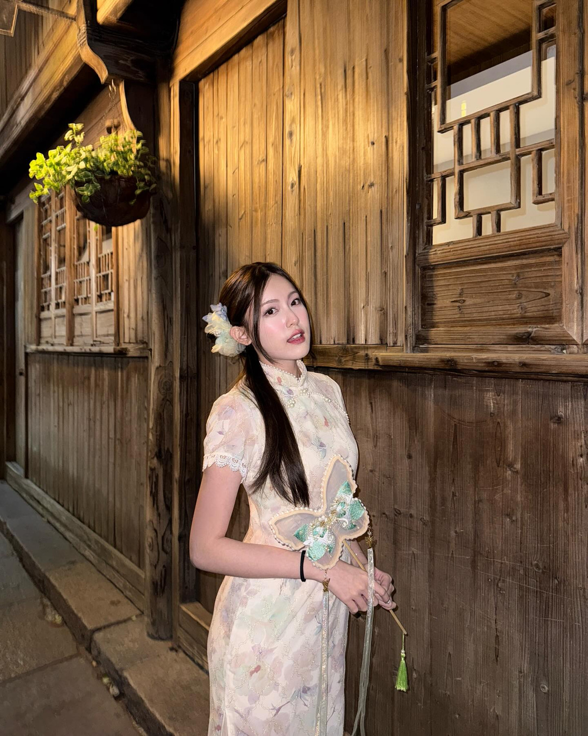 Chiếc sườn xám ôm sát cơ thể với chất liệu ren nhẹ, hoa văn pastel tinh tế mang lại cảm giác mềm mại, bay bổng và vô cùng nữ tính.