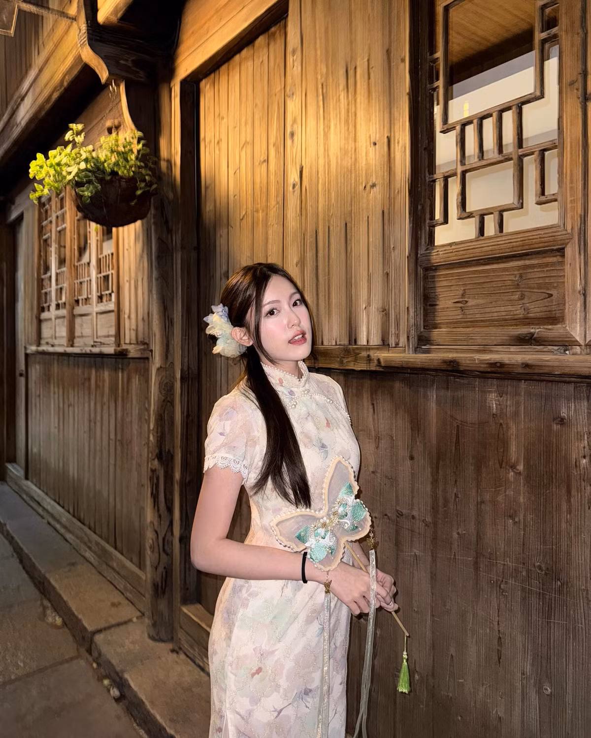 Chiếc sườn xám ôm sát cơ thể với chất liệu ren nhẹ, hoa văn pastel tinh tế mang lại cảm giác mềm mại, bay bổng và vô cùng nữ tính.