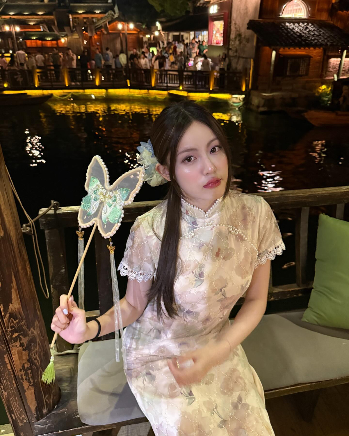 Điểm nhấn là chiếc quạt cầm tay hình bướm ngọt ngào, càng làm tăng thêm nét cổ điển và thơ mộng cho tổng thể.