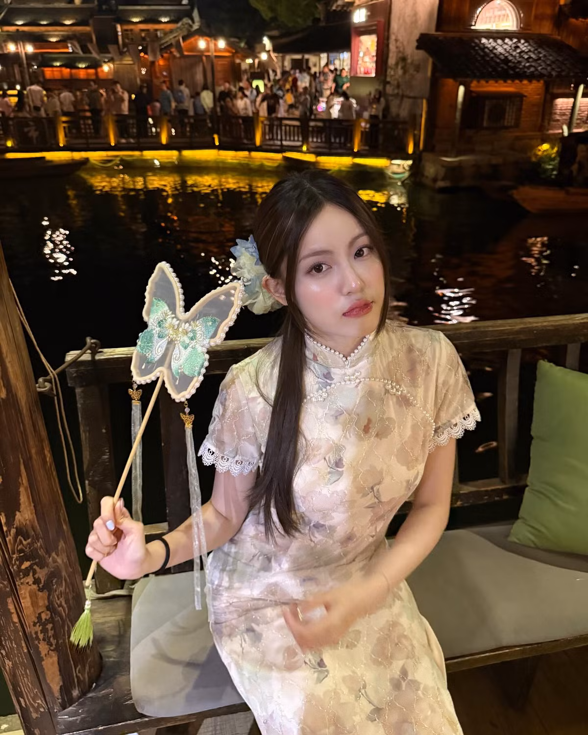 Điểm nhấn là chiếc quạt cầm tay hình bướm ngọt ngào, càng làm tăng thêm nét cổ điển và thơ mộng cho tổng thể.