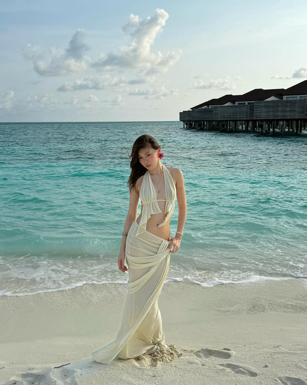 Trước đó, Ly Phạm diện một set đồ biển màu kem nhã nhặn nhưng đầy phá cách, gồm áo yếm cách điệu khoe lưng trần nuột nà, kết hợp cùng chân váy quấn hờ tinh tế, tạo nên tổng thể vừa mềm mại, vừa gợi cảm.