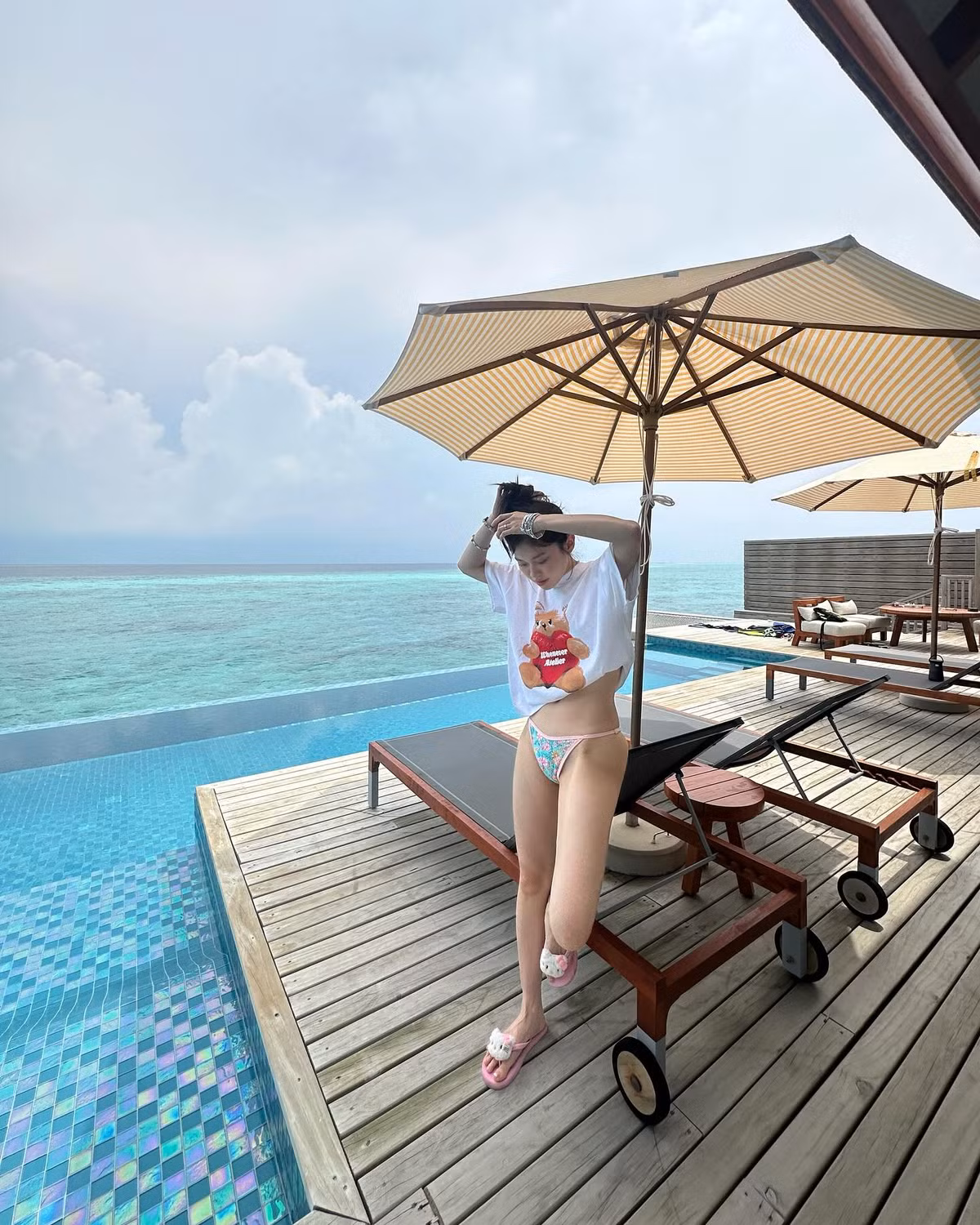 Trong bộ bikini hoa pastel ngọt ngào, Ly Phạm khoe trọn body mảnh mai mà quyến rũ. Làn da trắng hồng tựa sứ, đôi chân thon dài cùng vòng eo phẳng lì giúp cô nàng nổi bật như nàng thơ giữa không gian trong xanh và những bậc gỗ mộc mạc trên mặt nước.