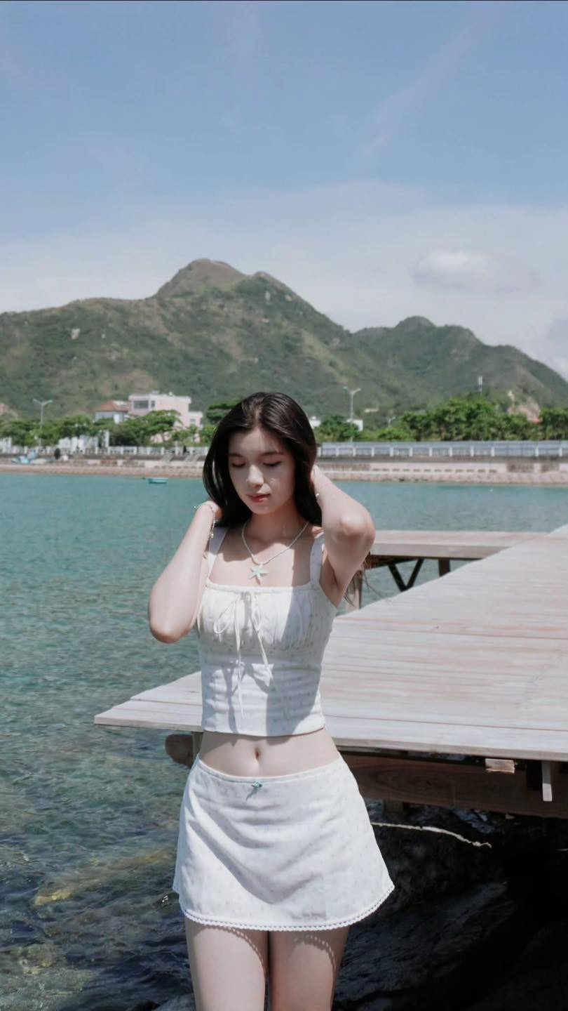 Tạm rời xa màu áo lính cùng nét nghiêm trang, Bảo Chinh khoác lên mình bộ trang phục trắng tinh khôi, khoe nhan sắc trong trẻo cùng nụ cười rạng rỡ dưới nắng biển.