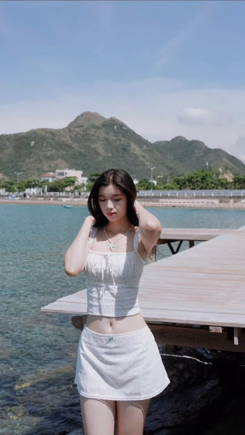 Tạm rời xa màu áo lính cùng nét nghiêm trang, Bảo Chinh khoác lên mình bộ trang phục trắng tinh khôi, khoe nhan sắc trong trẻo cùng nụ cười rạng rỡ dưới nắng biển.