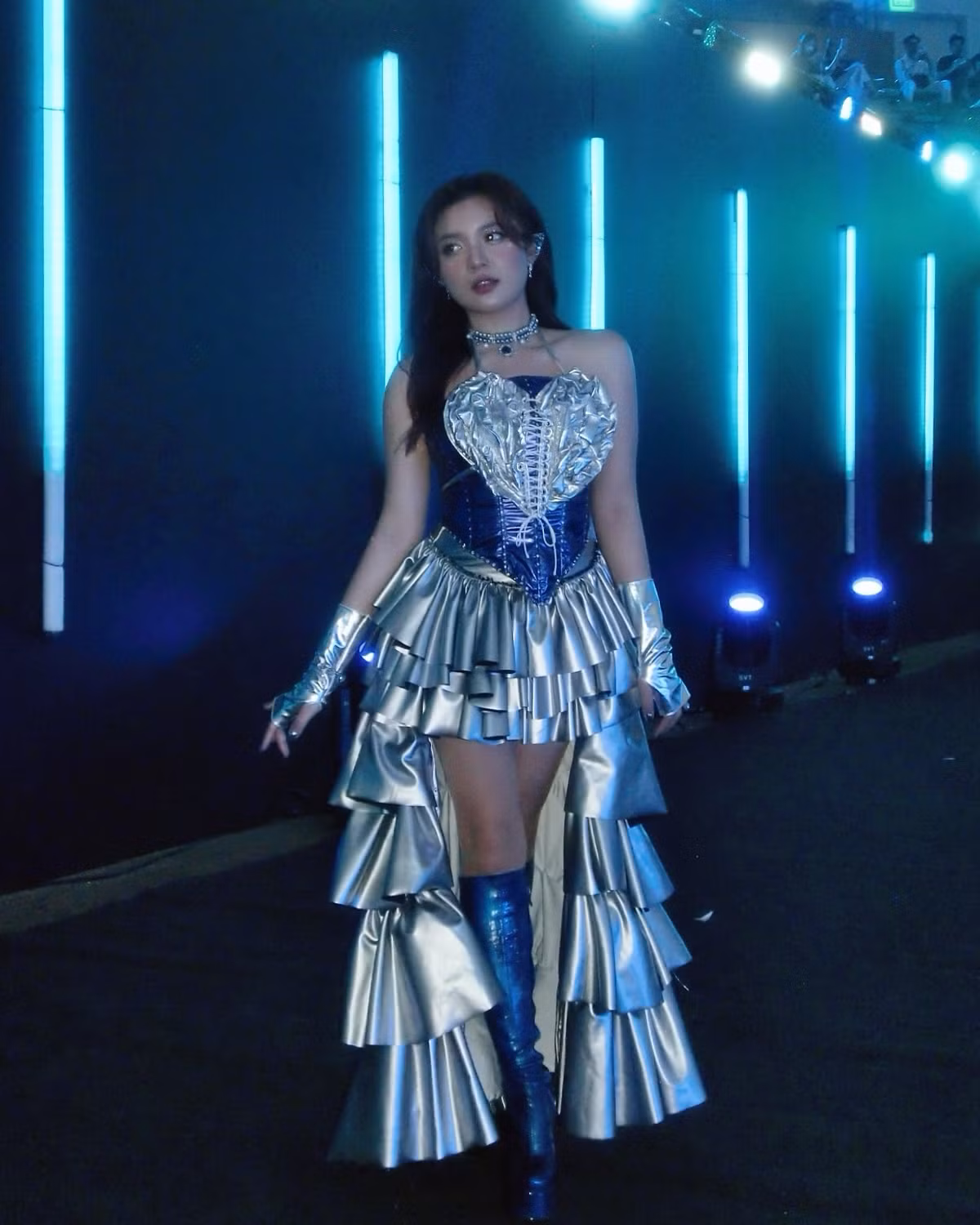 Điểm nhấn còn nằm ở phần găng tay kim loại và boots cao quá gối, khiến cô nàng trông như vừa bước ra từ một vũ trụ thời trang siêu thực