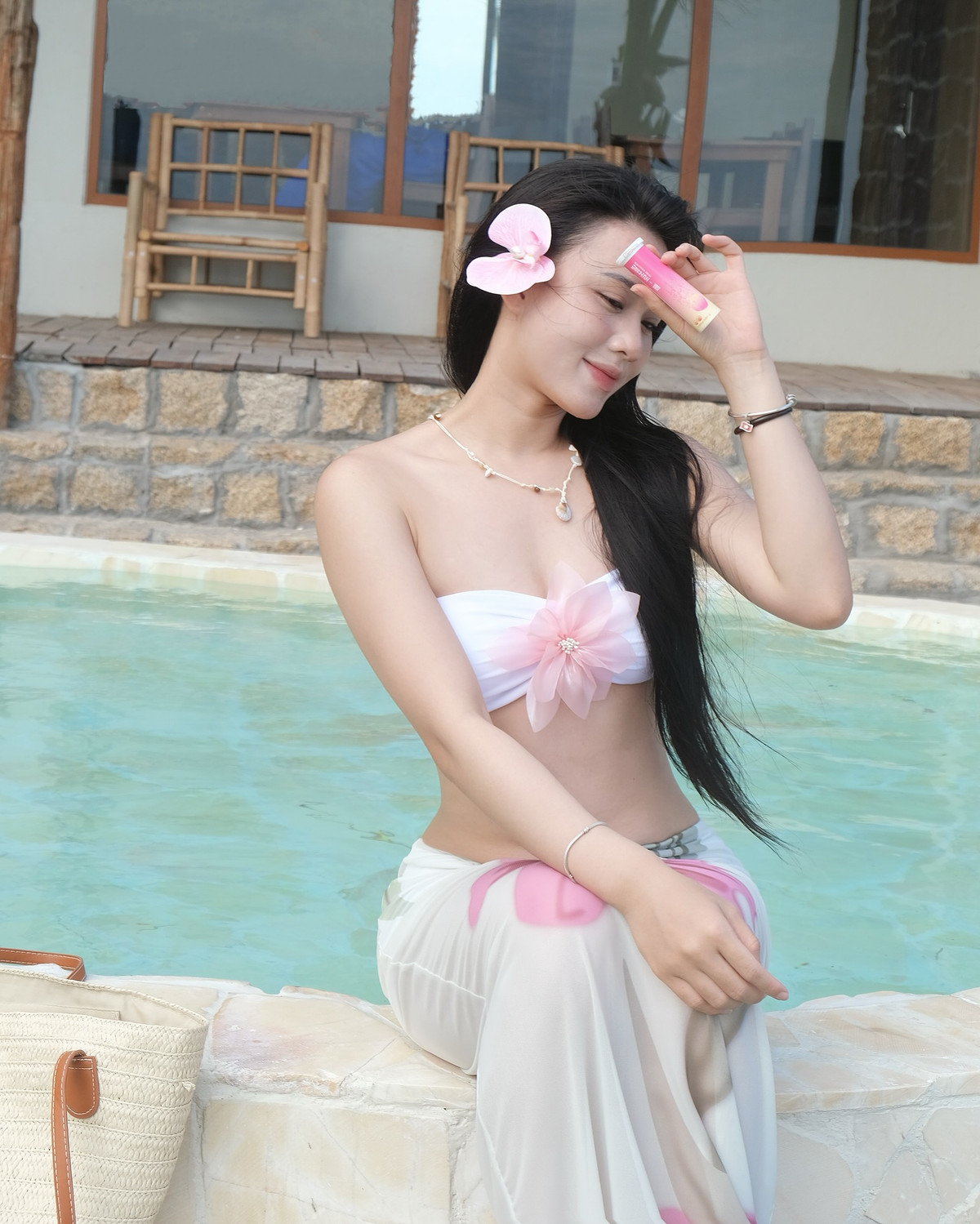 Hoa Mỹ cũng thể hiện gu thời trang tinh tế qua phụ kiện đi kèm: túi cói vintage, vòng cổ ngọc trai và bông hoa cài tóc ton-sur-ton. Mọi thứ đều được phối hợp nhịp nhàng, không hề thừa thãi.