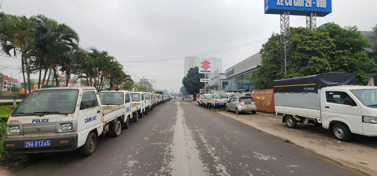 Hàng dài xe công vụ của ngành công an nằm nối đuôi hai bên đường, chiếm một phần diện tích của tuyến đường.