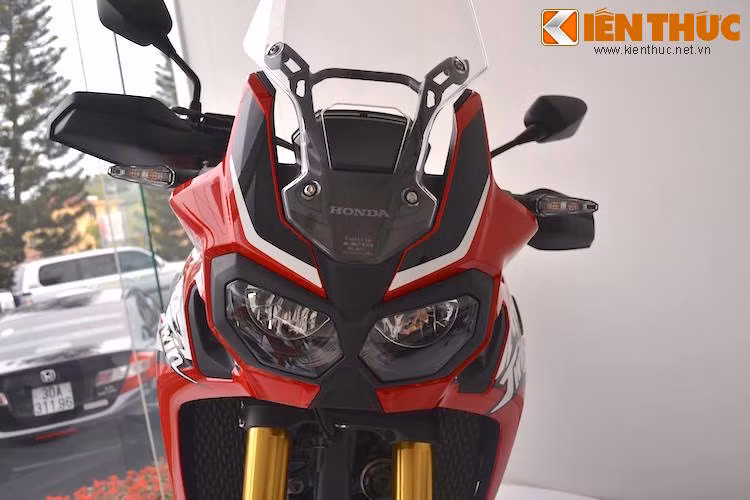 Phần đầu xe thể thao, góc cạnh và mạnh mẽ với cặp đèn pha kép bao quanh bởi nhựa đúc màu đen. Phía trên là chiếc kính chắn gió cao, hạn chế tạt gió và bụi khi điều khiển Africa Twin qua những chuyến "phượt" xuyên lục địa.