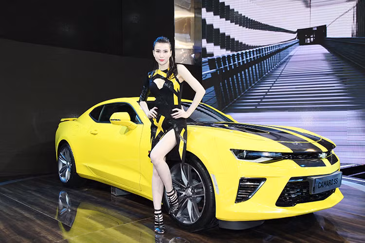 Năm nay, "tâm điểm" của khu trưng bày Chevrolet Việt Nam là mẫu xe cơ bắp Camaro 2017 phiên bản cao cấp nhất SS. Nó được đặt ở vị trí trang trọng nhất, cùng với đó là cô nàng chân dài với bộ đồ "sẹc tông".